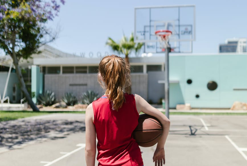 child carrying a basketball